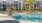 Elegant apartment complex in Sacramento with resort-style pool, modern loungers, and lush palm trees, perfect for luxury living.
