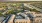 Aerial view of a modern apartment complex in Natomaswith a beautifully landscaped courtyard and pool, surrounded by lush greenery and vibrant cityscape at sunrise.