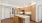 Modern kitchen with sleek wooden cabinetry, stainless steel appliances, and a stylish island centerpiece under bright recessed lighting at Ona Natomas in Sacramento