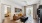 Chic living room with a cozy brown sectional sofa, abstract art, and natural light streaming through large windows, opening to a stylish bedroom at Ona Natomas in Sacramento